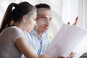 Close up spouses reading letter feels confused