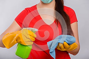 Close-up of spray bottle and rag in the hands of a cleaning lady.