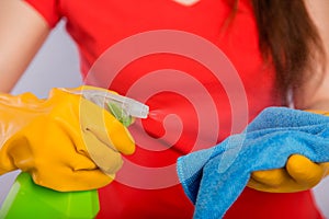 Close-up of spray bottle and rag in the hands of a cleaning lady.