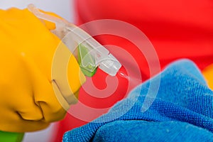 Close-up of spray bottle and rag in the hands of a cleaning lady.