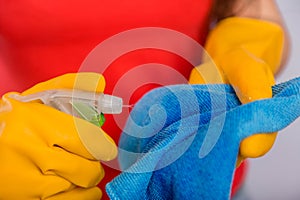 Close-up of spray bottle and rag in the hands of a cleaning lady.