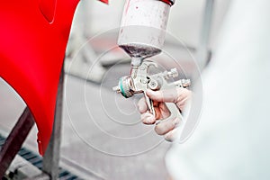 Close up of spray gun painting a car