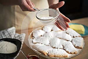 Close up of sprinkling and decorating cookies with powdered sugar