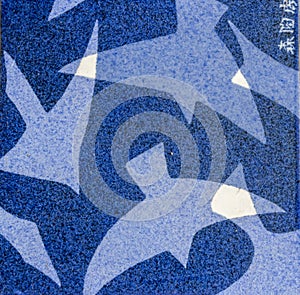 close up of square traditional Tobeyaki indigo blue ceramic tile with stylized birds design background