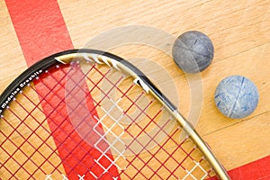 Close up of a squash racket and ball on the wooden background