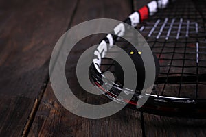 Close up of a squash racket and ball on the wooden background