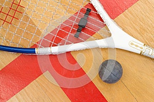 Close up of a squash racket and ball on the wooden background, sport concept