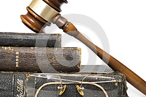 Close Up Three Antique Bibles with Gavel and Rimless Glasses on