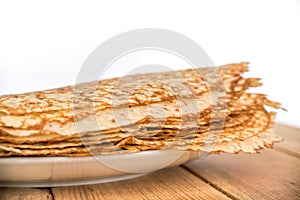 Close up on a stack of crepes french pancakes on a plate, white background