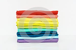 Stack of folded colorful t-shirt on white background