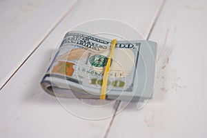Close-up of a stack of hundred-dollar bills on a light background