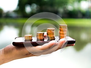 Close up stack of money coins on the mobile phone, business in eCommerce concept