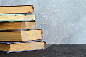 Close-up of stack of old used books background. Pile of vintage old hardback books. Back to school. Copy space