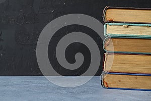 Close-up of stack of old used books background. Pile of vintage old hardback books. Back to school. Copy space