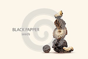 Close-up of a stack of Organic dried black pepper seeds, whole and sliced peppercorn on a beige background.Tower of picy Seasoning