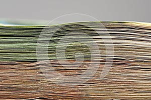 Close-up of a stack of paper bills, side view. Euro banknotes stacked on top of each other. Big pile of money.