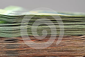 Close-up of a stack of paper bills, side view. Euro banknotes stacked on top of each other. Big pile of money.