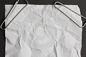 Close up of a stack of papers and paper clip on black background