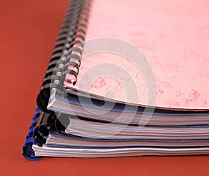 Close-up of a stack of spiral notebooks / reports