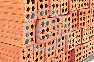 Close up of stacked clay bricks - constructional material - industrial production of bricks