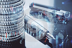 Close up of stacked coins and fountain pen, glowing candlestick forex chart and map hologram on blurry background. Stock,