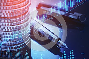 Close up of stacked coins, pen and forex chart on blurry desktop background. Financial management, money and data concept. Double