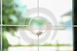 Close up of stacked wedding rings of groom and bride on window grating with bokeh background