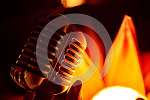 Close-up stage retro microphone, orange tint, different focus.