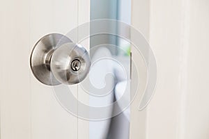 Close-up stainless door knob, with door open slightly photo