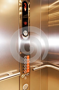 Close up of stainless steel elevator panel push buttons.