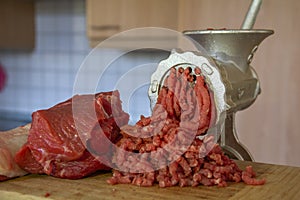 Close up Stainless steel Meat grinder with prepared meat and kitchen Background. Traditional manual meat grinder