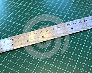 Close up of stainless steel metal ruler on a cutting mat