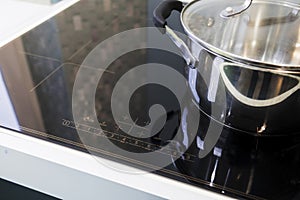 Close-up of stainless steel pots on an induction cooker in a modern kitchen. the concept of a modern kitchen