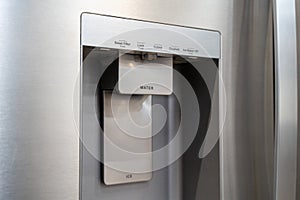 Close up of stainless steel refrigerator water and ice dispenser panel