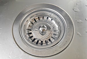 Close up stainless steel sink plug hole be filled with dust debris
