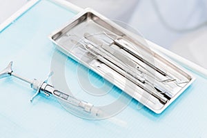 Close-up of a staminological instrument next to a metal syringe. Dental equipment. Dental hygiene and healthcare concept