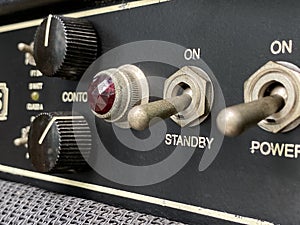 Close-up stanby switch vintage head power amplifier with black knob and control panel. clean and hi-gain distortion.