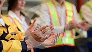 Close-up standing ovation of worker wearing safety uniform in factory plan.