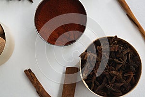 Star anise and chili powder in bowl with cinnamon stick