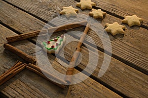 Close up of star shape cookies by Christmas tree made with cinnamon stick