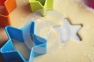 Close up star shaped cookie cutters in dough