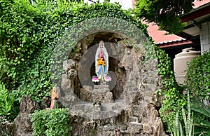 Statue of Our lady of grace virgin Mary view with natural background in the rock cave at Thailand. selective focus.