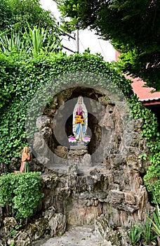 Statue of Our lady of grace virgin Mary view with natural background in the rock cave at Thailand. selective focus.