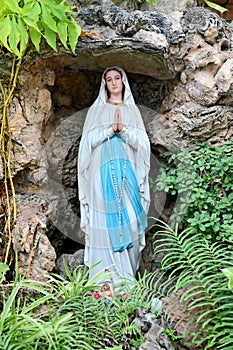 Statue of Our lady of grace virgin Mary view with natural background in the rock cave at Thailand. selective focus.