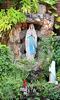 Statue of Our lady of grace virgin Mary view with natural background in the rock cave at Thailand. selective focus.