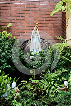 Statue of Our lady of grace virgin Mary view with natural background in the rock cave at Thailand. selective focus.