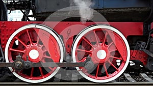 Close-up of a steam locomotive wheels at a railway station