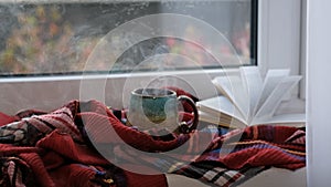 Close up. Steaming coffee cup on a rainy day window background. cozy atmosphere, in cold weather. Rainy Day Mood.