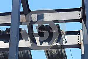 Close-up of steel frameworks at a construction site against a blue sky