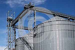 Close-up of steel grain storage silos with conical bottom, can be used for various purposes. Against the backdrop of a beautiful photo